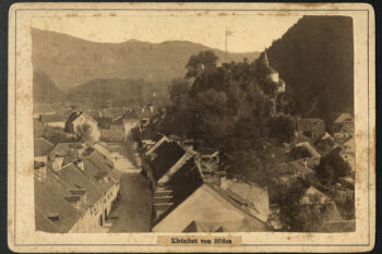 Ob svojem obisku Kamnika leta 1887, se je blejski fotograf Benedikt Lergetporer povzpel v zvonik župnijske cerkve na Šutni in od tam ujel v fotografski objektiv prehod iz predmestja Šutna v Kamnik, nad katerim se na desni strani vzpenja pobočje Malega gradu z ruševinami stražnega stolpa in kapelo v ozadju. Pet let pred nastankom posnetka, leta 1882, so na pobudo župana Maksimilijana Samca (1844-1889) znižali prehod iz Šutne v mesto na Klancu. Nastal je Samčev predor.