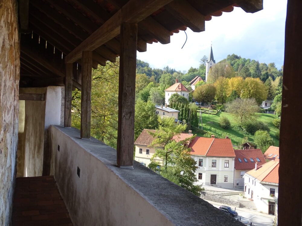 Pogled s severnega obhodnega hodnika proti kamniškim Žalam. V spodnjem delu fotografije vidimo mestne hiše na severnem pobočju Klanca. Na vzpetini stoji Rauterjeva graščina, imenovana tudi Trutzturn ali Smoletov gradič. Nad njo vidimo pokopališko cerkev Marijine in Jožefove zaroke na Žalah, ki je bolj poznana kot cerkev sv. Jožefa.